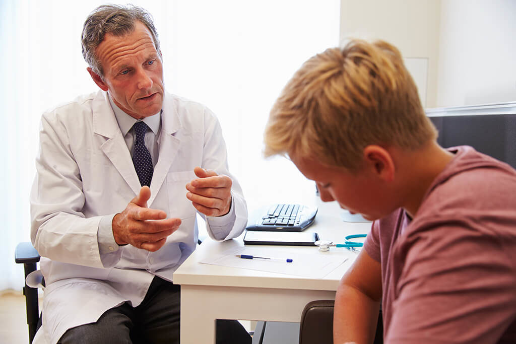 Doctor Treating Teenage Boy Suffering With Depression